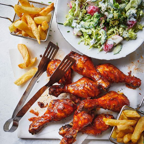 Sticky chicken drumsticks and chips with American-style salad