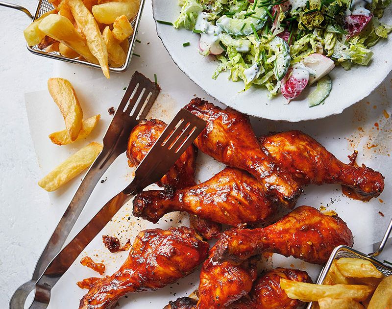 Sticky chicken drumsticks and chips with Americanstyle salad
